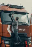 Model year 2025 : Renault Trucks T High Smart Racer : lifestyle (Renault Trucks Hero Zip Hoodie) driver on windshield access steps cleaning rearview mirror) 